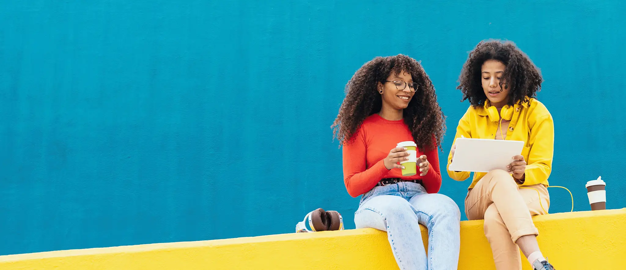 Two girls sitting on a wall